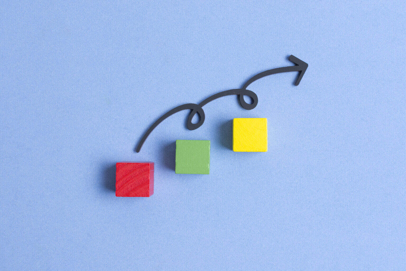 Curvy line jumping on three colourful cubes symbollizing continous improvement