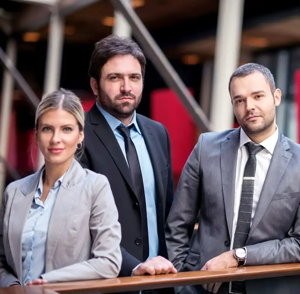 Group of interim quality managers standing together leaning against rail